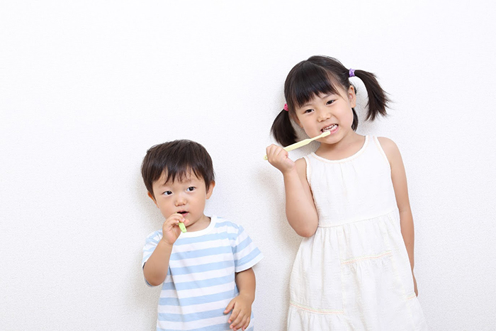 歯磨きをする小さい女の子と男の子